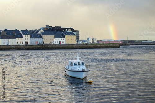 Obraz na płótnie Beautiful cityscape sunrise scenery with old wooden boat in Corrib river at Claddagh in Galway city, Ireland, architecture background w salonie