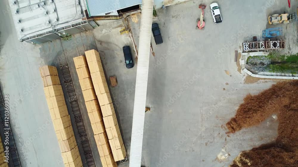 Aerial shot of an industrial area showing buildings, vehicles, machines and pallets of wood stacked ready to go to the wood dryer.