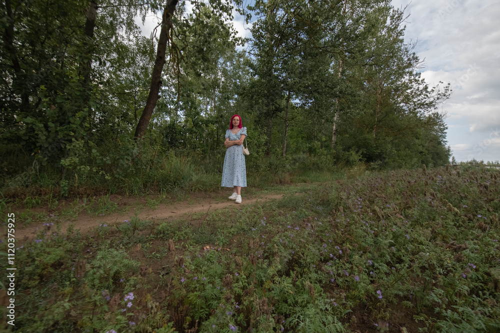Young beautiful girl with red hair in nature in a beautiful summer dress. Young beautiful girl with red hair in nature in a beautiful summer dress.