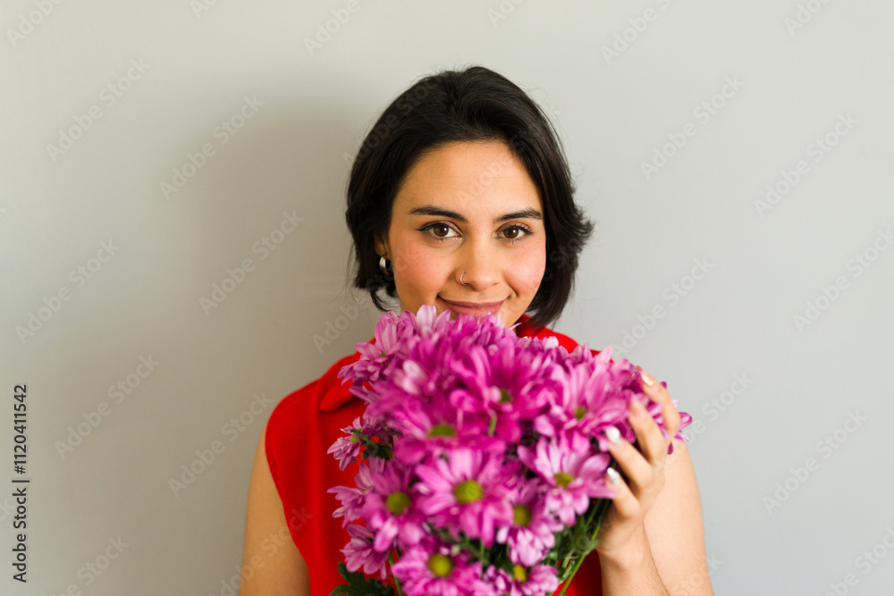Happy young woman smelling a bouquet of pink flowers celebrating valentine's day Happy young woman smelling a bouquet of pink flowers celebrating valentine's day