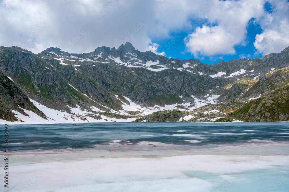 Breathtaking View of Snow-Capped Mountains and Serene Lake in Pinzolo, Italy During Summer Breathtaking View of Snow-Capped Mountains and Serene Lake in Pinzolo, Italy During Summer
