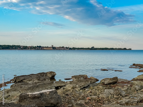 Scenic view of picturesque coastal town Dajla seen from rocky shoreline of Karigador, Istria peninsula, Croatia. Village is nestled along the waterfront of Adriatic Mediterranean sea. Summer vacation
