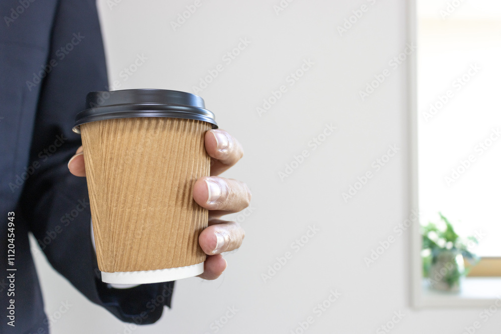 スーツを着て紙コップのコーヒーを持つ男の手(30代、日本人)
