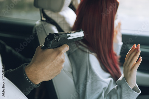 A robber with a gun and a mask attacked a female driver inside a car