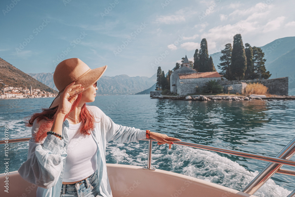 Young woman enjoying the view of scenic islands from a boat, during excursion or trip in the bay of Kotor, Montenegro