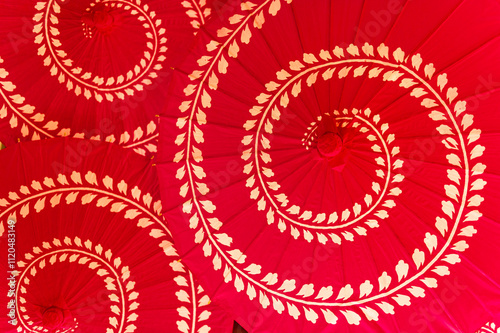 Three spiral-patterned Chinese style red umbrellas at a wedding celebration, seen from above photo