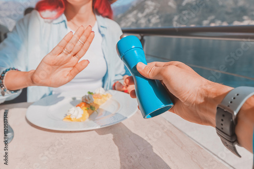 Obraz na płótnie Woman refusing salt while having breakfast at restaurant by the sea w salonie