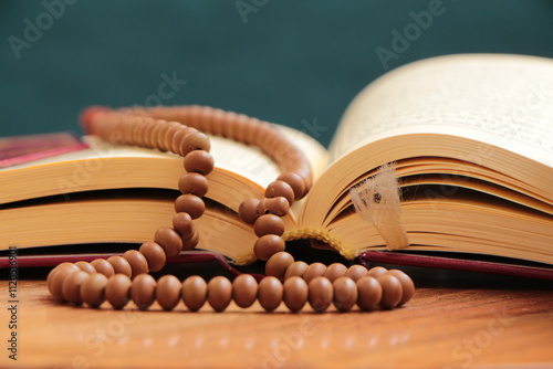 The Muslim Holy Quran and islamic prayer beads made of skittle tree. Opened Quran( the islamic holy book) with rosary bead. Reading Kuran. photo