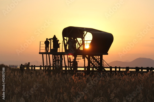 Image of people enjoying a beautiful sunset at Dadaepo Beach in Busan and a landscape image of sunset at sea
 photo