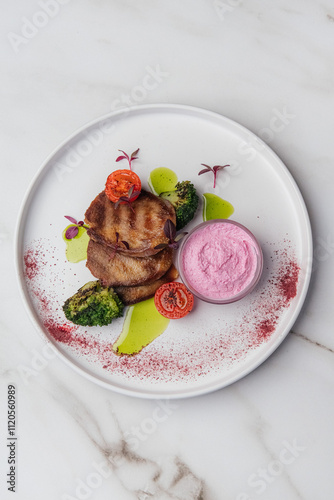 Slices of grilled beef tongue are served with horseradish sauce, broccoli, cherry tomatoes, and microgreens, creating a flavorful dish on a white plate. Restaurant or cafe menu, cookbook recipe
