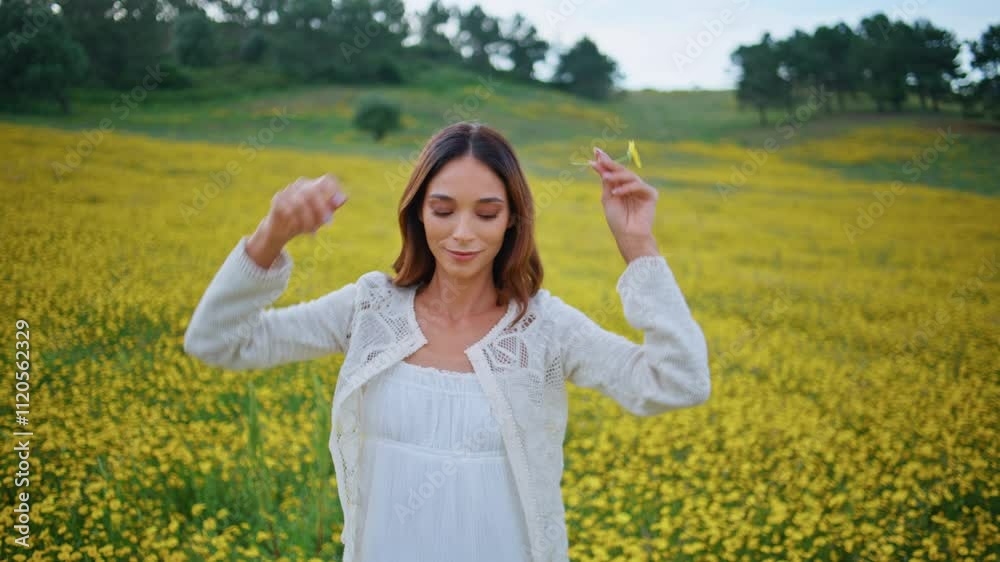 Rural girl spreading arms holding wildflower at bloomy yellow meadow closeup Rural girl spreading arms holding wildflower at bloomy yellow meadow closeup