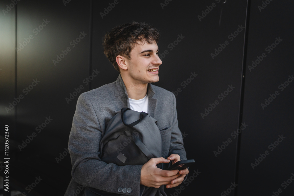 Portrait of young man sit on bench with backpack and use mobile phone Portrait of young man sit on bench with backpack and use mobile phone