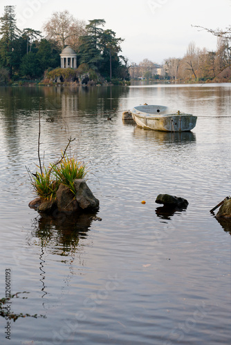 Bois de Vincennes offers a serene view with a small boat floating on water surrounded by beautiful nature and distant architecture photo