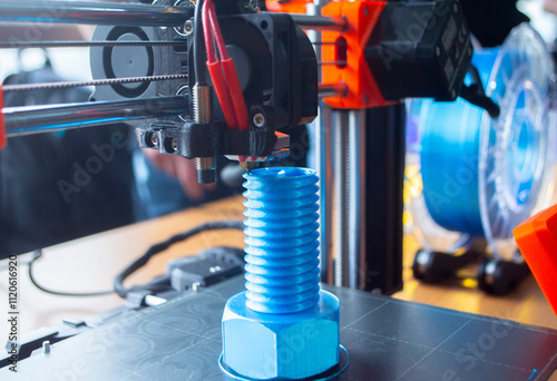 3D printer printing prototype of bolt from molten plastic. Process of creating prototype model of bolt on 3D printer from blue melted plastic close-up. Additive new printer technology. Modern printing