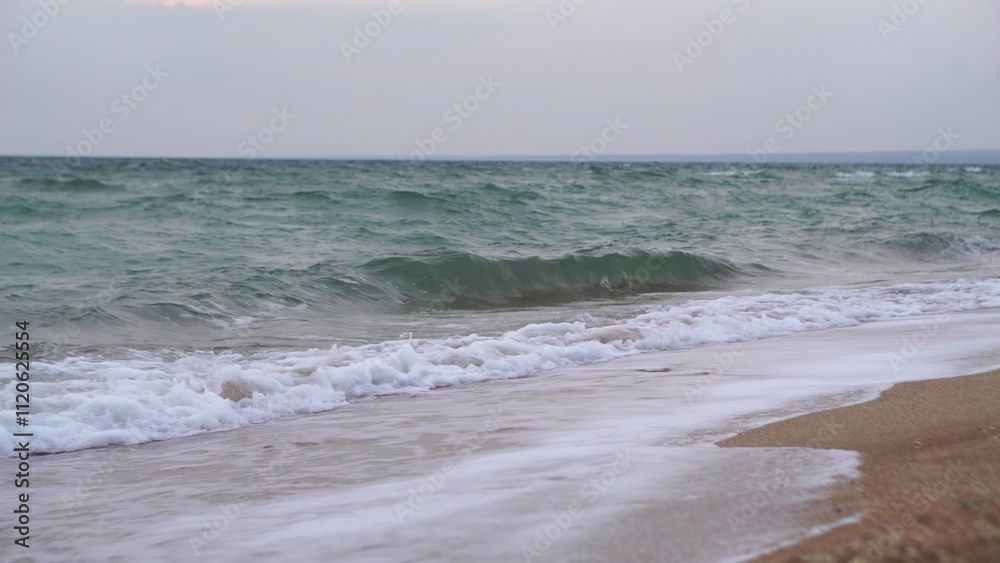 Waves crashing on the sand at a beach with the ocean behind Waves crashing on the sand at a beach with the ocean behind