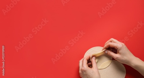 Hands shaping dough on red background photo