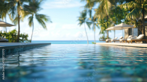 Beautiful infinite outdoor swimming pool with a blurred blue ocean view