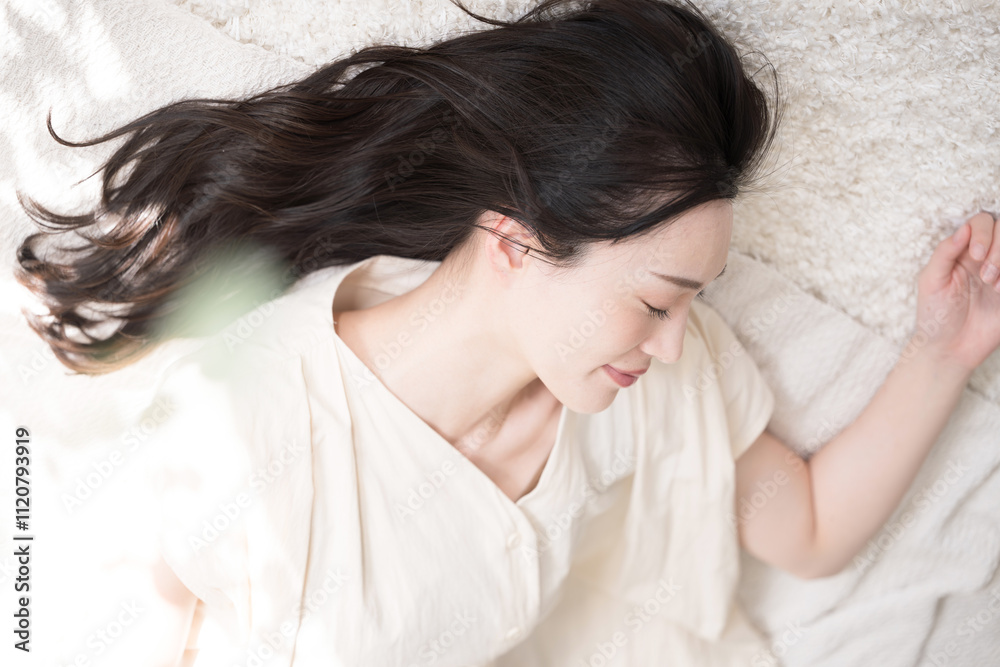 仰向けで目を閉じる美しい大人の女性 お昼寝や睡眠イメージ 緑の前ボケあり 仰向けで目を閉じる美しい大人の女性 お昼寝や睡眠イメージ 緑の前ボケあり