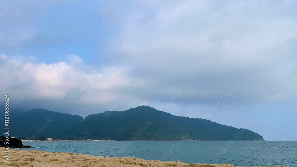 Time-lapse da baia com nuvens na montanha em dia parcialmente nublado e com maré bem baixa. Ao fundo, algumas embarcações navegando e uma montanha com floresta de Mata Atlântica envolvida pela neblina Time-lapse da baia com nuvens na montanha em dia parcialmente nublado e com maré bem baixa. Ao fundo, algumas embarcações navegando e uma montanha com floresta de Mata Atlântica envolvida pela neblina