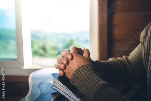 Close up of a man praying on bible and  guitar for worship God at the window, christian background, devotional concept.