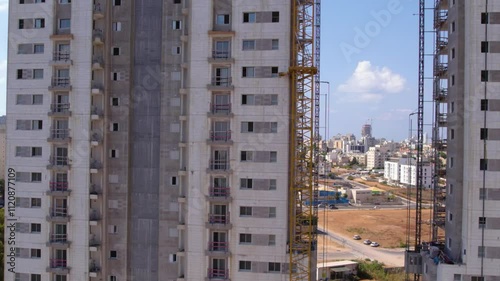 Aerial shot to the top of building under construction with crane 4K 60fps