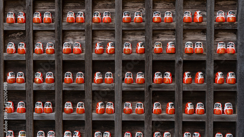 A Daruma doll is a hollow, round, Japanese traditional doll modelled after Bodhidharma, the founder of the Zen tradition of Buddhism. These are smaller Darumas.  photo