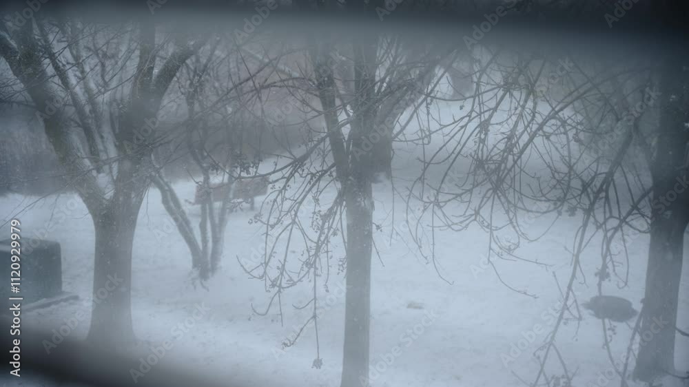 Winter landscape through the window in house. falling snow outside. Slow motion