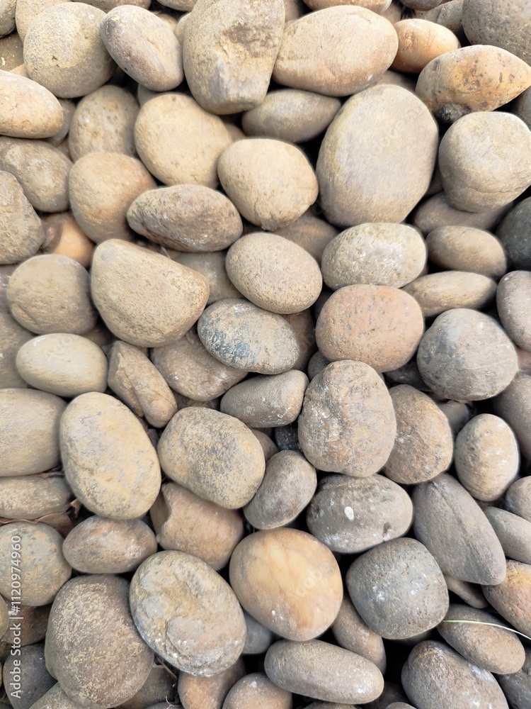 Smooth stone wall background with pebbles on the beach and a textured rocky surface Smooth stone wall background with pebbles on the beach and a textured rocky surface