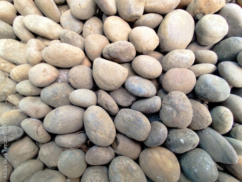 Smooth stone wall background with pebbles on the beach and a textured rocky surface Smooth stone wall background with pebbles on the beach and a textured rocky surface