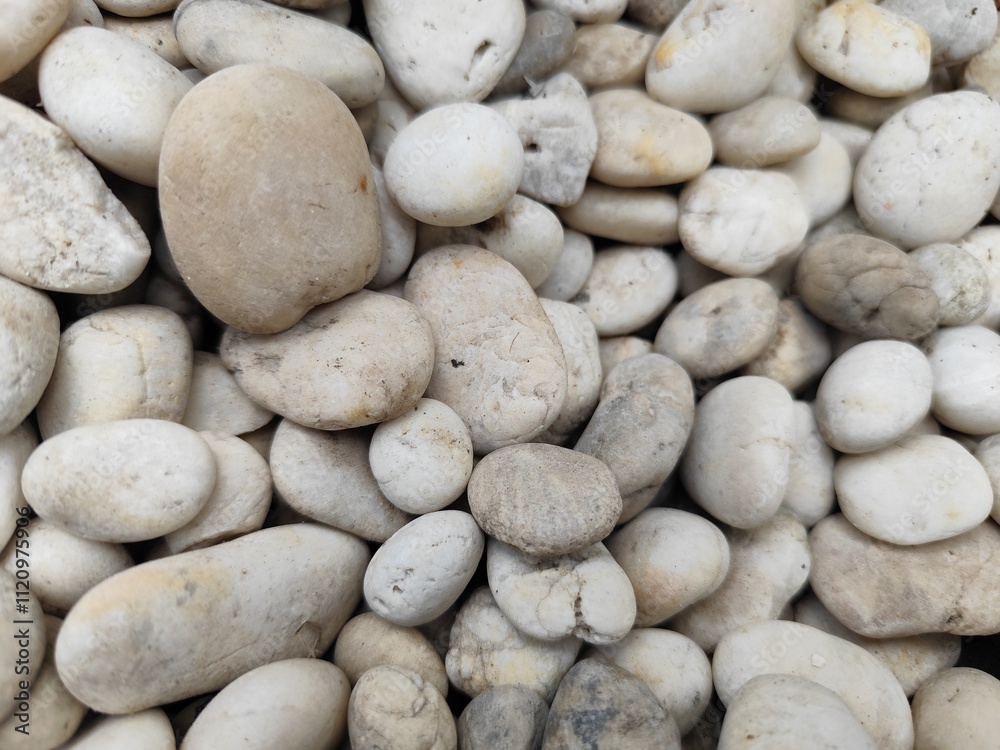 Smooth stone wall background with pebbles on the beach and a textured rocky surface Smooth stone wall background with pebbles on the beach and a textured rocky surface