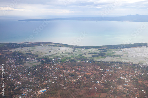 Aerial view of Kupang city, the capital of East Nusa Tenggara Province, Indonesia. Urban landscape with coastline, settlements, built-up areas and some agricultural areas. photo