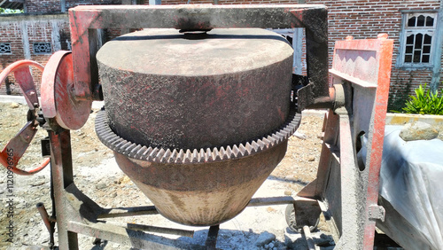 dirty concrete mixer at building construction site photo