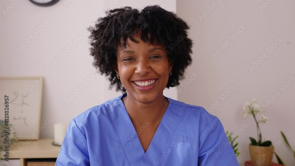 Portrait of young black female healthcare worker smiling at camera. Young nurse with blue scrubs listening patient through web virtual conference. Hospital medical lifestyle and health care concept.