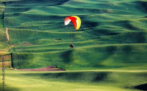 Colorful glider flying over rolling hills of Palouse ,Washington