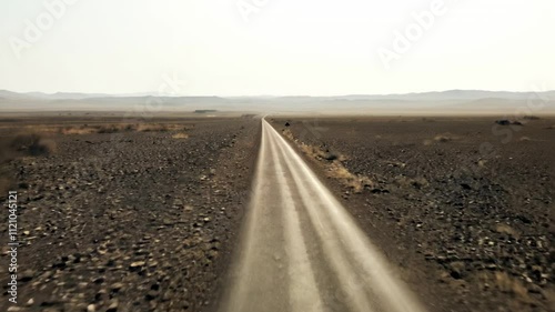 A desolate road stretches into the horizon, surrounded by barren landscapes.