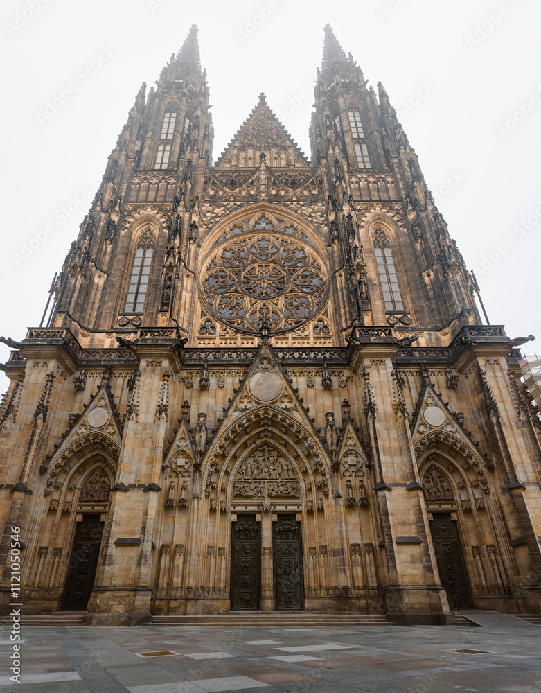 Fototapeta premium Main facade of the Gothic Cathedral of St. Vitus in Prague on a foggy day, Czechia.