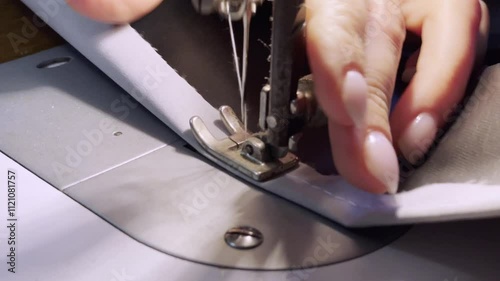 close up of a sewing machine needle in the activity of someone sewing clothes