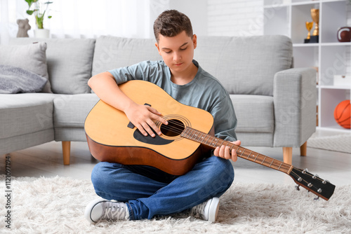 Teenage boy playing guitar at home photo