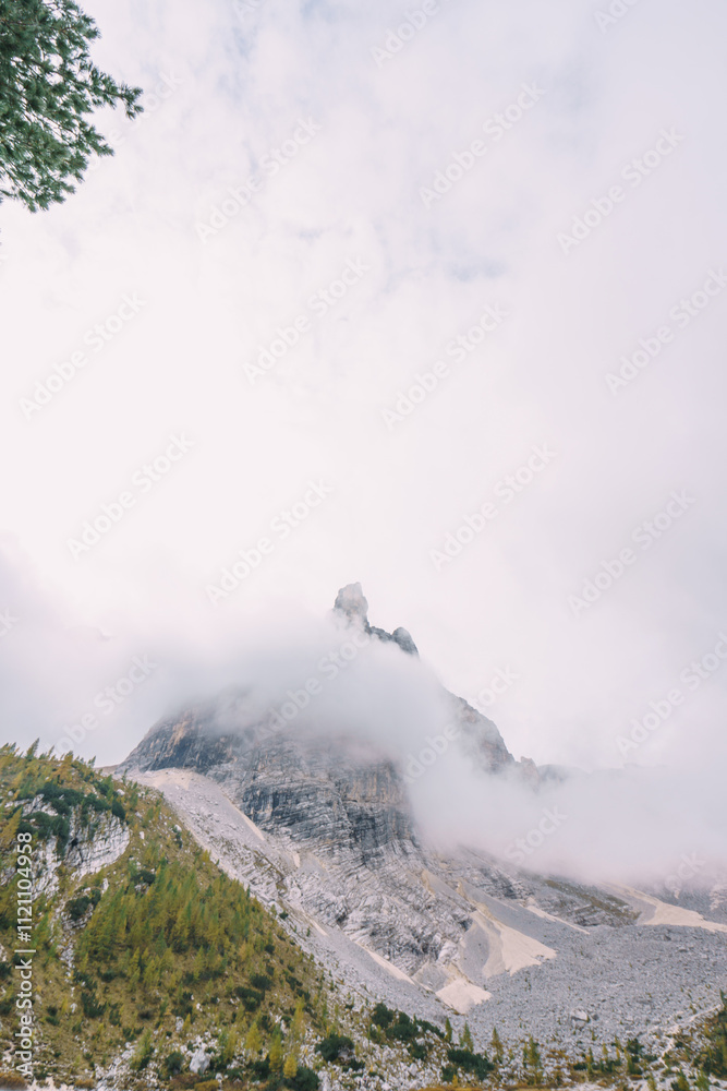 Fototapeta premium A rocky shoreline with a body of water that is blue in color lake sorapis dolomites