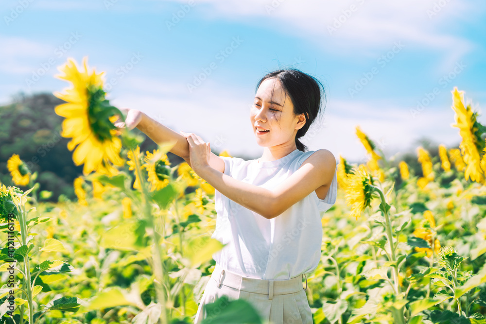Solitude and freedom woman standing relax in sunflower botanical field park outdoors with sunlight Solitude and freedom woman standing relax in sunflower botanical field park outdoors with sunlight