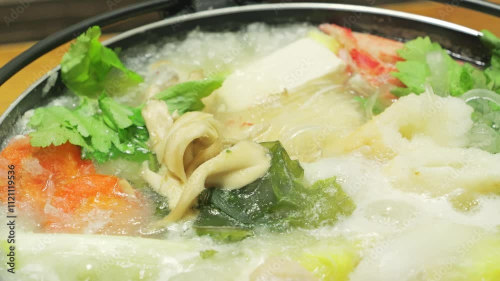 Vegetables, seafood, meat and mushrooms cooked in a pot, popular in winter in Japan and other Asian countries. Vegetables, seafood, meat and mushrooms cooked in a pot, popular in winter in Japan and other Asian countries.