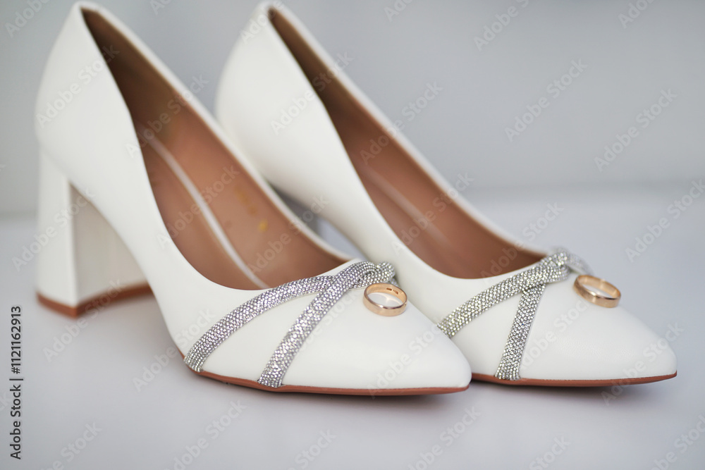 The bride's sandals and gold wedding rings on them. Preparation for the wedding. The bride's sandals and gold wedding rings on them. Preparation for the wedding.
