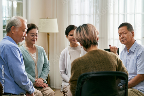 asian counselor facilitating a group discussion for senior women photo