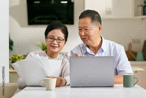 senior asian couple making financial plan using laptop computer photo