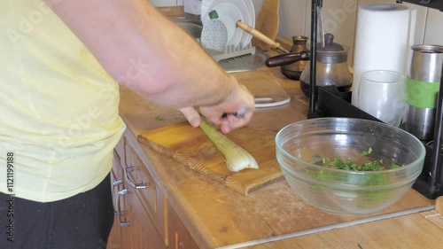 A man chops celery to prepare a salad