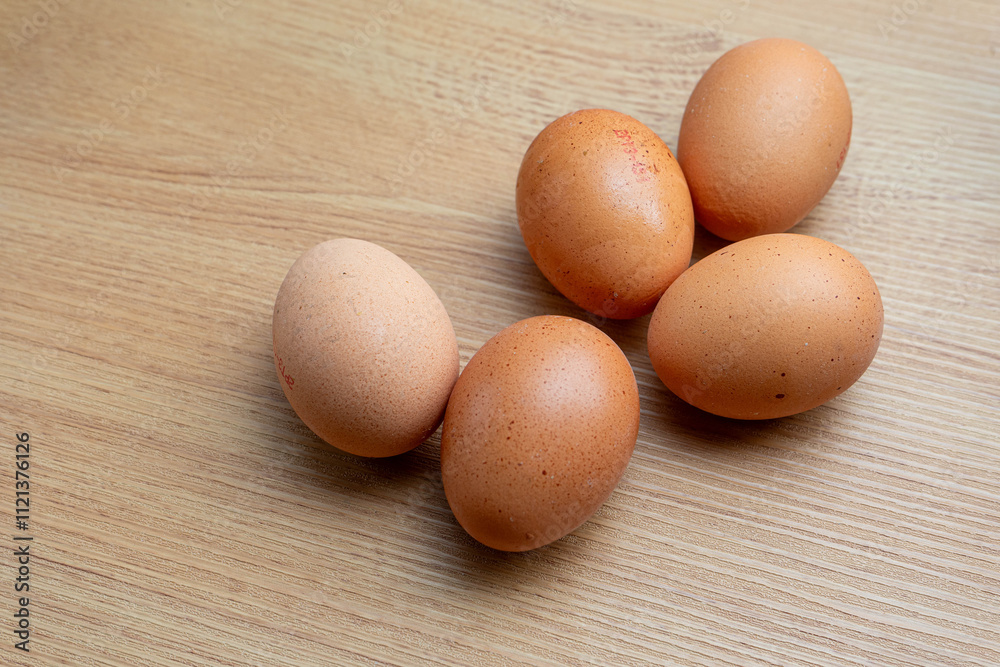 Fresh brown eggs on a rustic wooden kitchen countertop, illuminated by soft natural light, creating a warm and homely atmosphere. Perfect for food and farm-to-table concepts. Fresh brown eggs on a rustic wooden kitchen countertop, illuminated by soft natural light, creating a warm and homely atmosphere. Perfect for food and farm-to-table concepts.