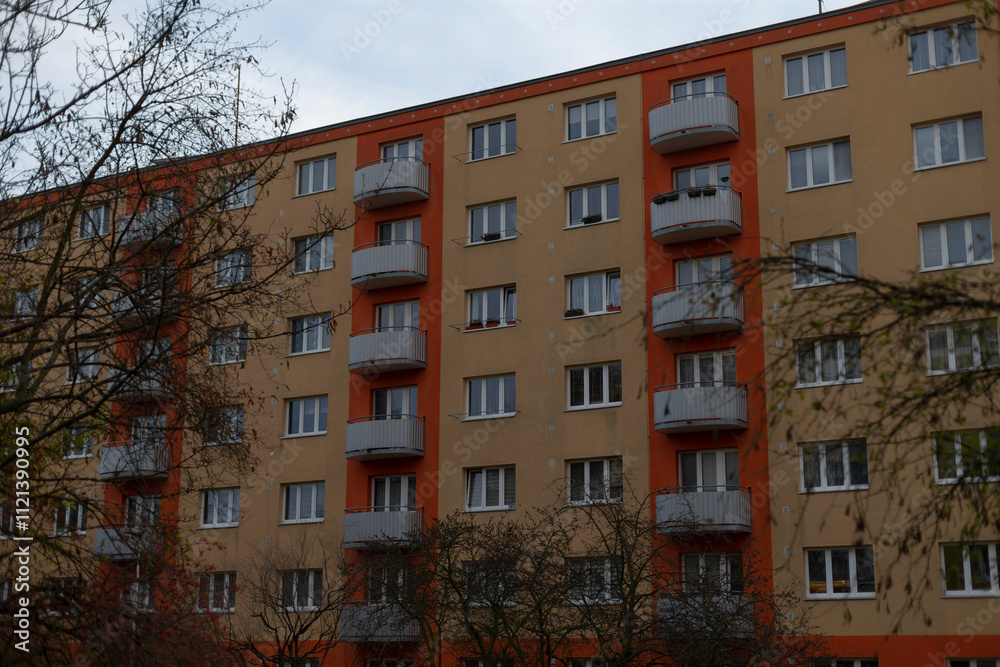 Naklejka premium A large, modern apartment building featuring numerous windows and spacious balconies overlooking the vibrant cityscape