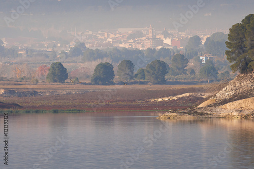 Paisaje con día invernal en el pantano de Beniarres con neblina y la población de Muro de Alcoy al fondo,  didciembre de 2024, España