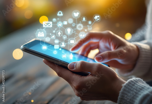 A person's hands holding a digital tablet or smartphone displaying various icons and symbols