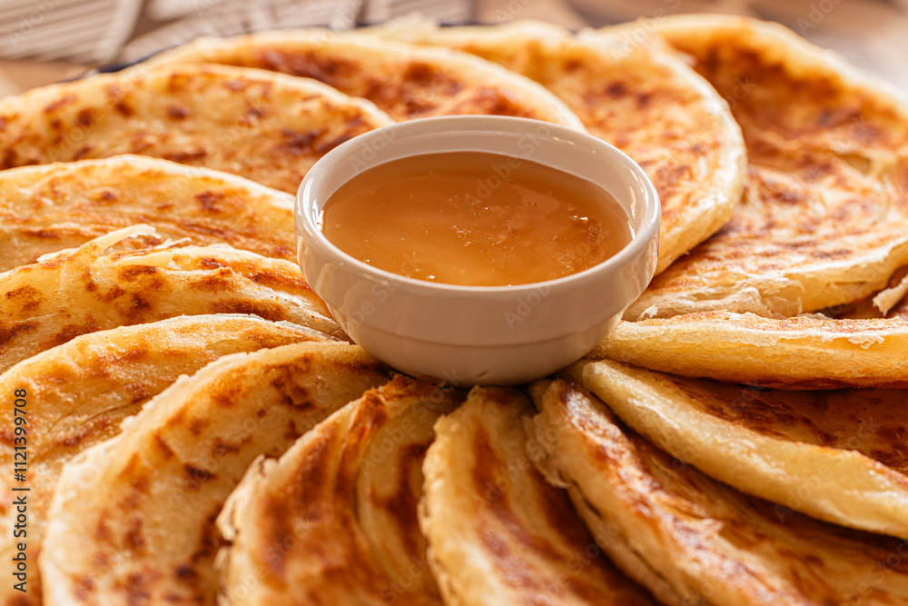 Msemen with crispy edges and soft layers, paired with golden honey, ready to be enjoyed on a wooden cutting board.